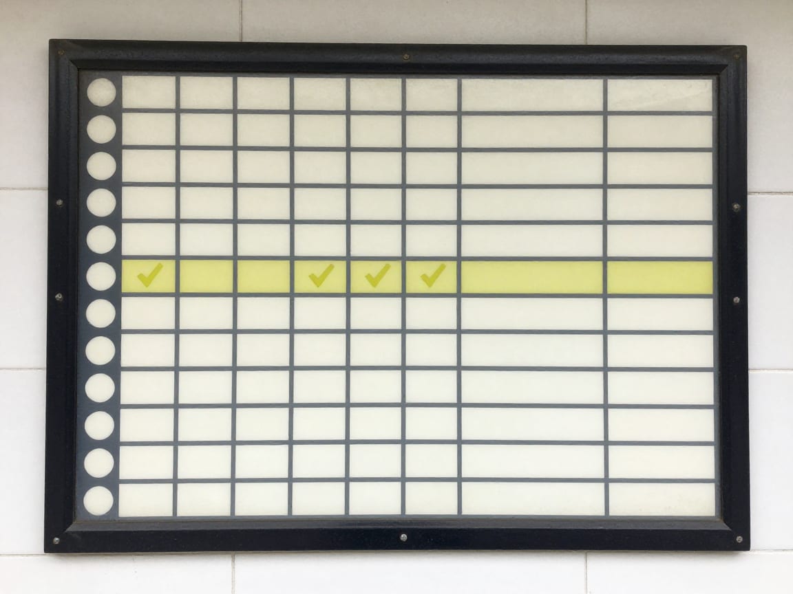 Enamel fare chart panel bolted to a concourse wall